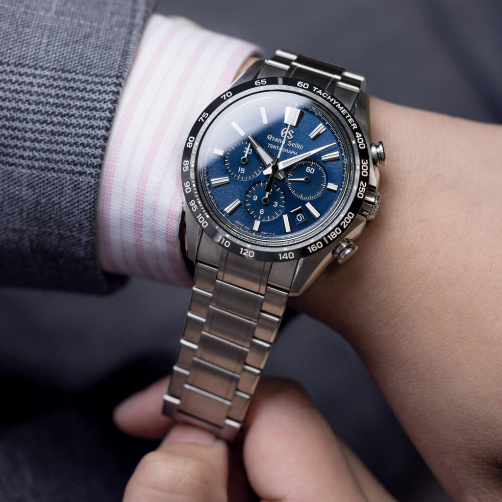 grand seiko watch with blue dial and stainless steel strap on mans wrist